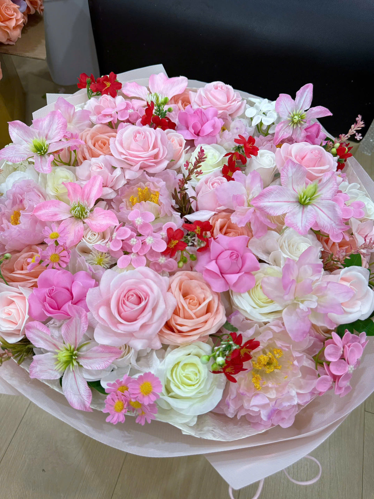 Round-shaped bouquet in pink with a few pops of red 🌸❤️