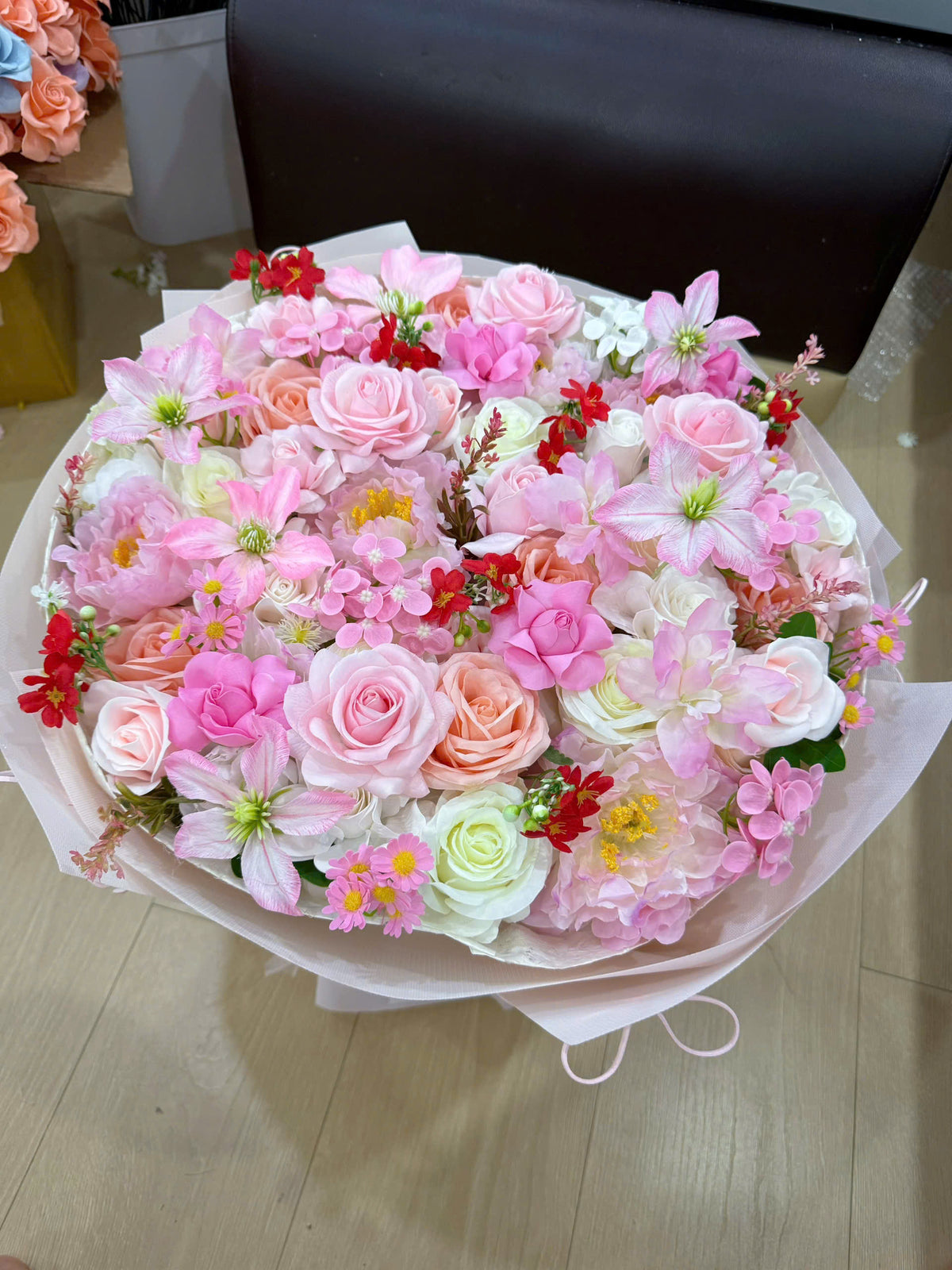 Round-shaped bouquet in pink with a few pops of red 🌸❤️