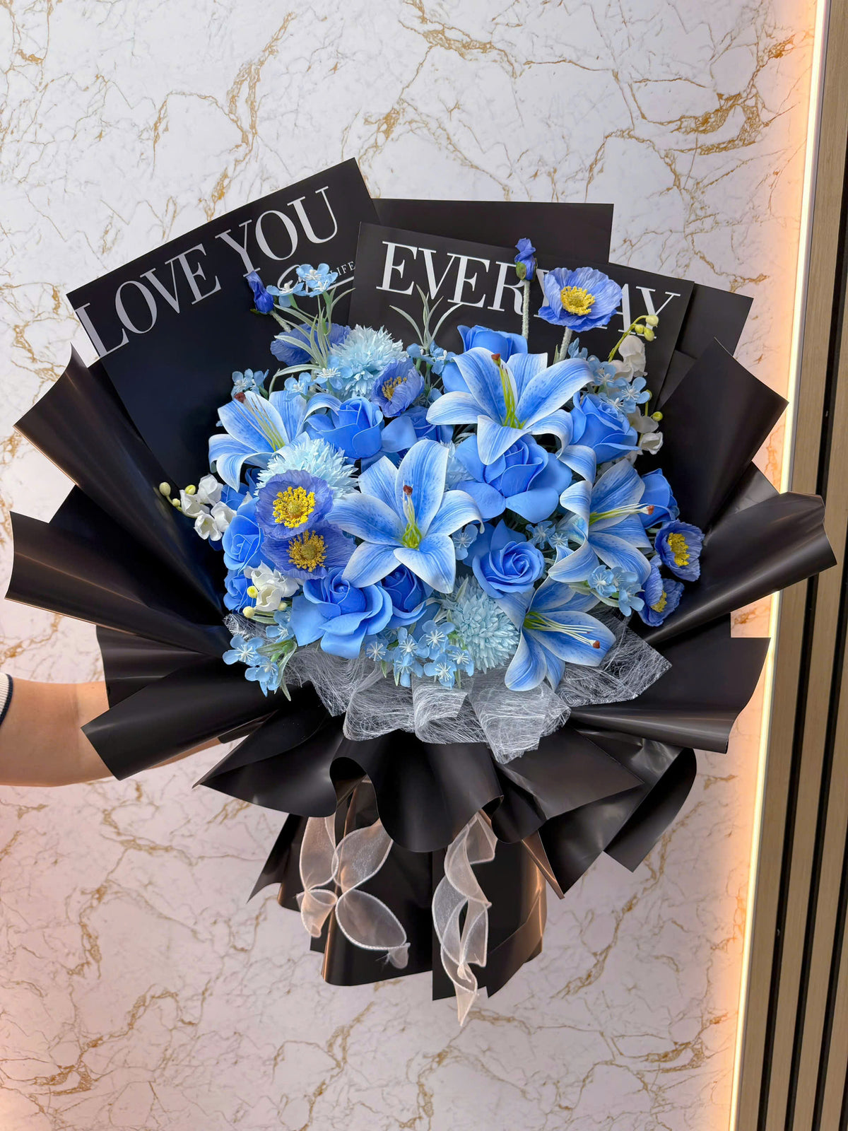 Blue flowers wrapped in black paper with a bold color combination