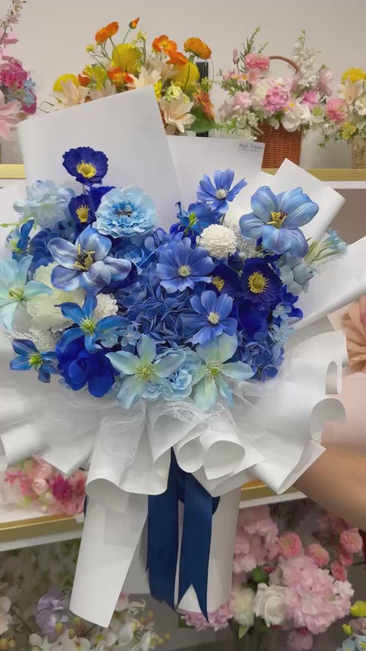 A blue-toned bouquet featuring a mix of different flowers