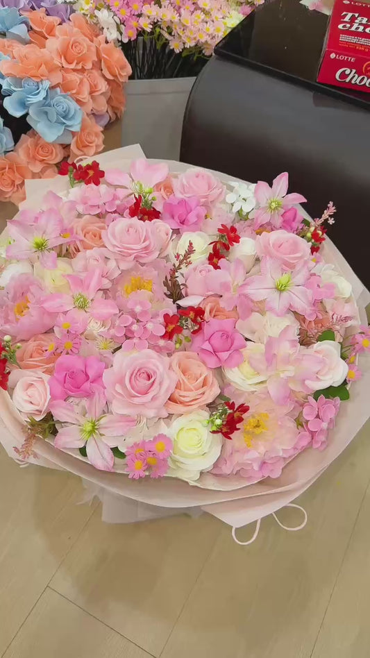Round-shaped bouquet in pink with a few pops of red 🌸❤️
